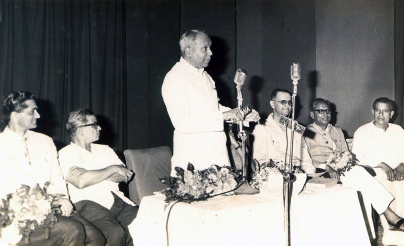 Seated on dias in a meeting organised for social development